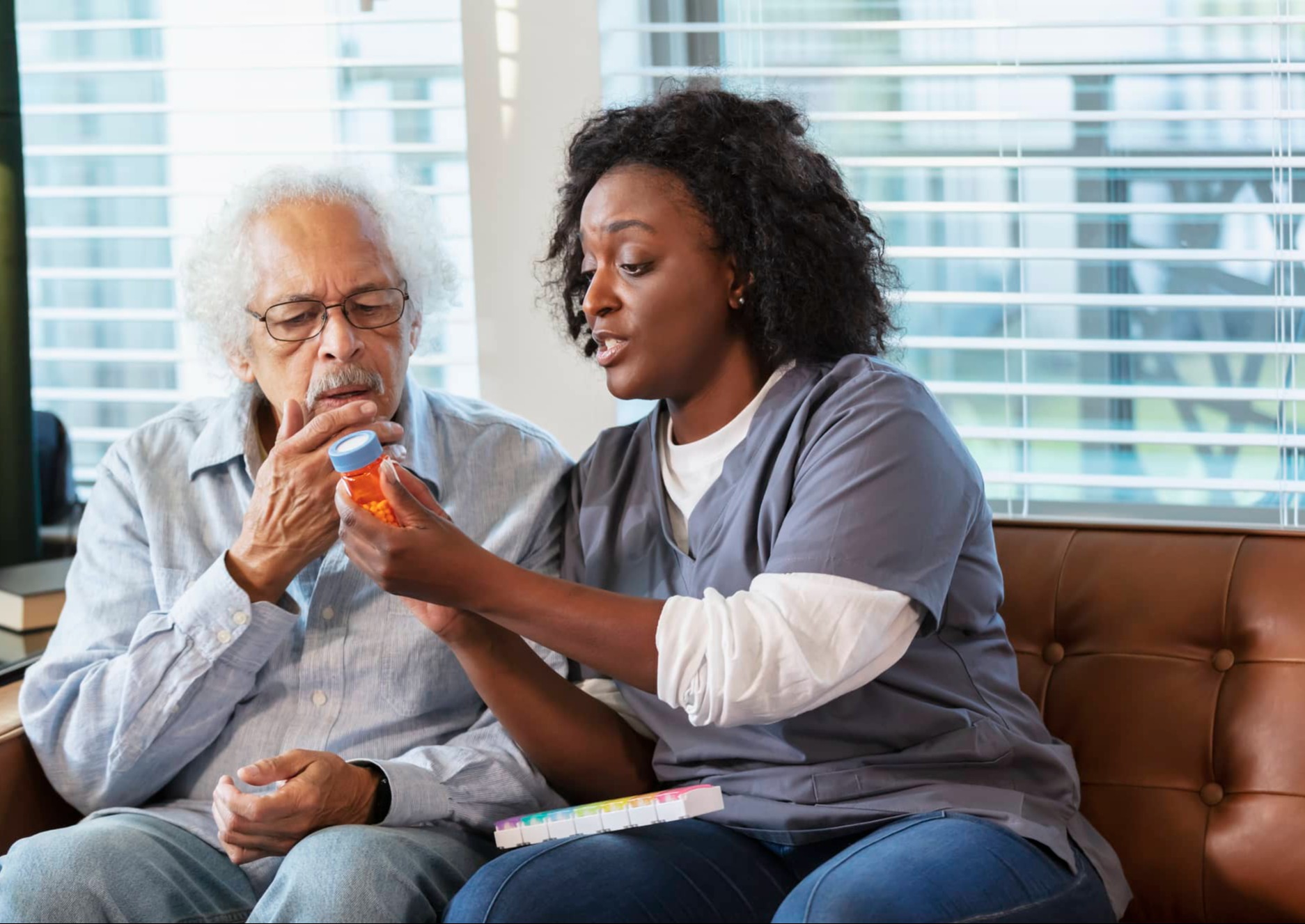 caregiver helps client look at medicine