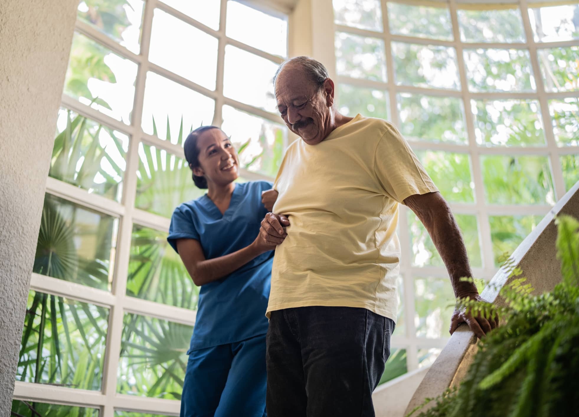 caregiver helps client down steps